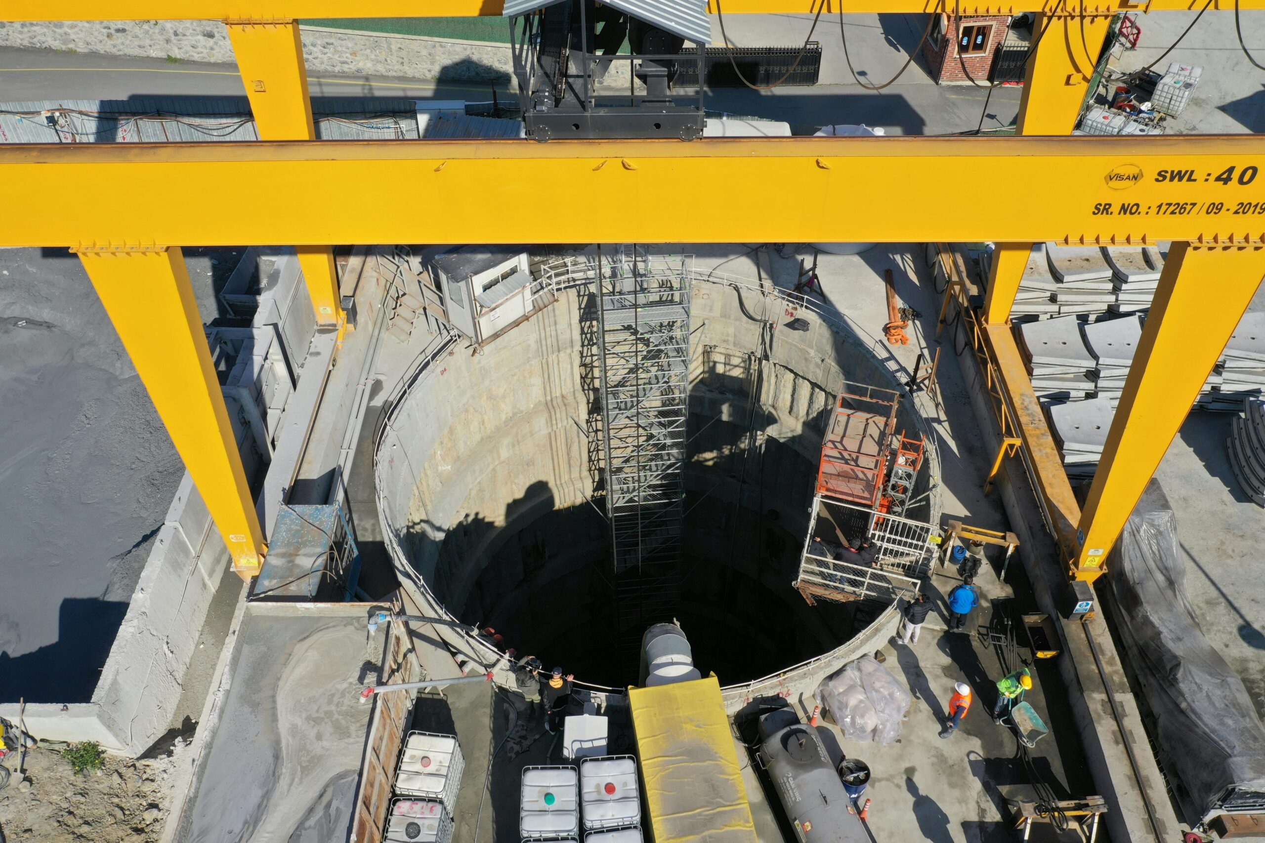 High angle view of an industrial construction site with a borehole and cranes.