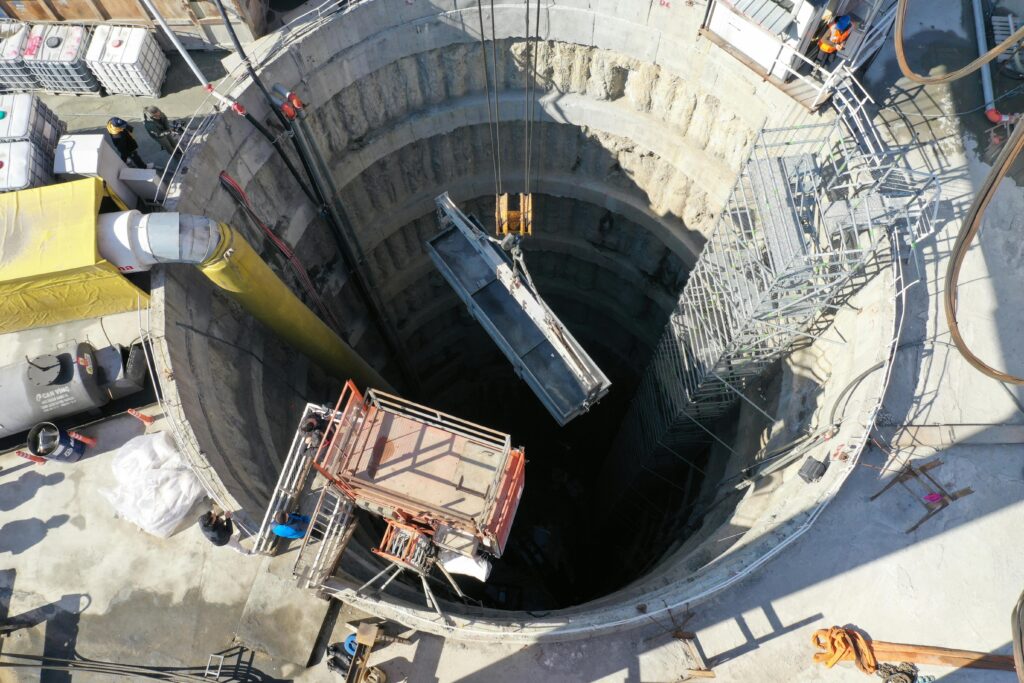 An aerial shot of a sunlit construction site highlighting a deep borehole in Istanbul.